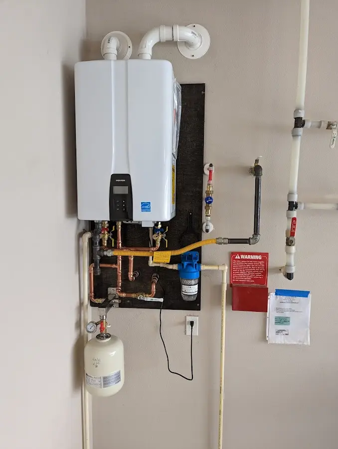 Professional plumber installing copper piping in a Roxboro home